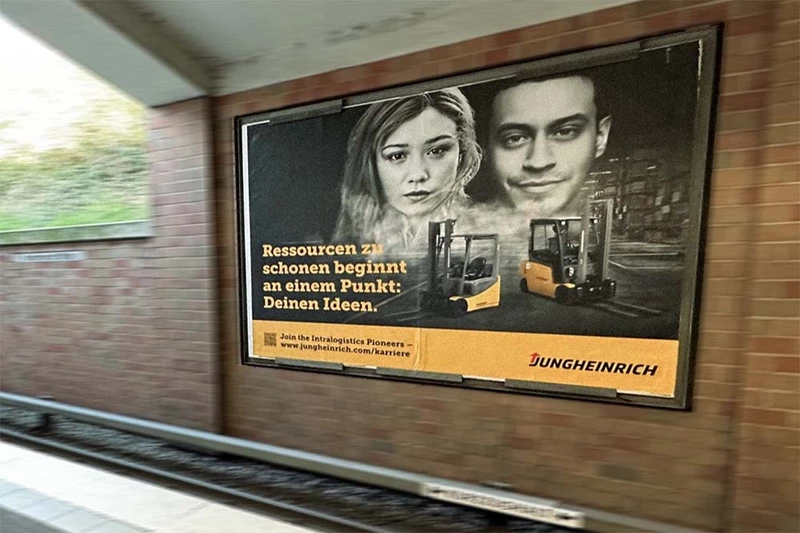 Gezeigt wird ein Jungheinrich Werbeplakat an einer großen Werbetafel in einem Tunnel am Bahngleis.
